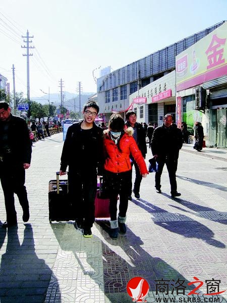 一對情侶模樣的人，一人拖一個拉桿箱